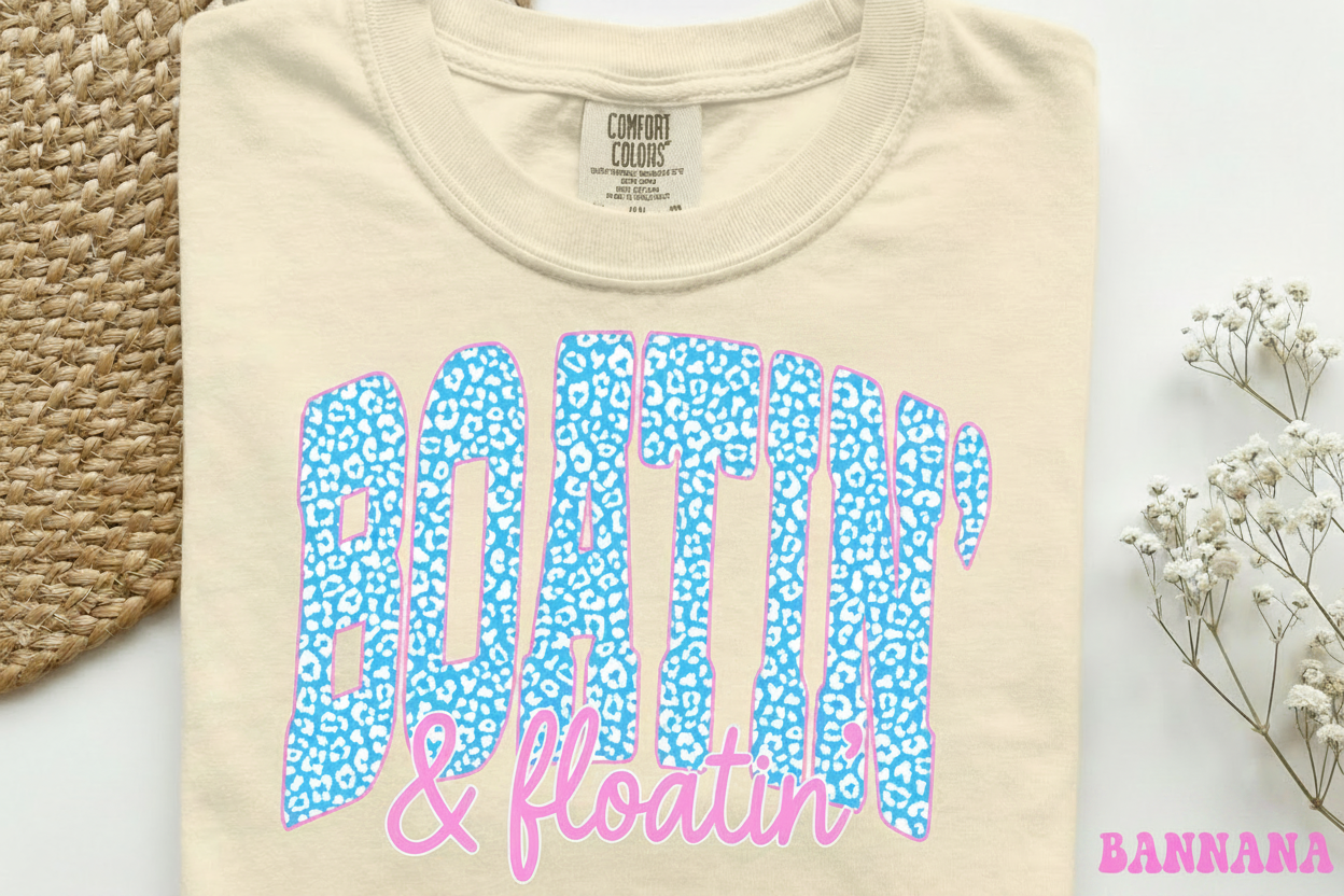 Beige Comfort Colors T-shirt with blue leopard-print Boatin' & Floatin' graphic in pink.