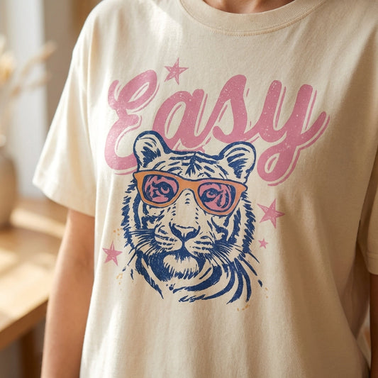 Close-up of vintage-inspired tiger graphic T-shirt with retro sunglasses and pink stars, showcasing the soft cotton blend fabric.