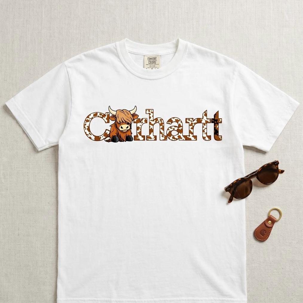 White graphic t shirt with western cow inspired design, styled flat lay with sunglasses and keychain