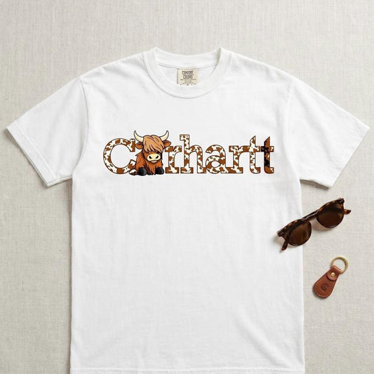 White graphic t shirt with western cow inspired design, styled flat lay with sunglasses and keychain