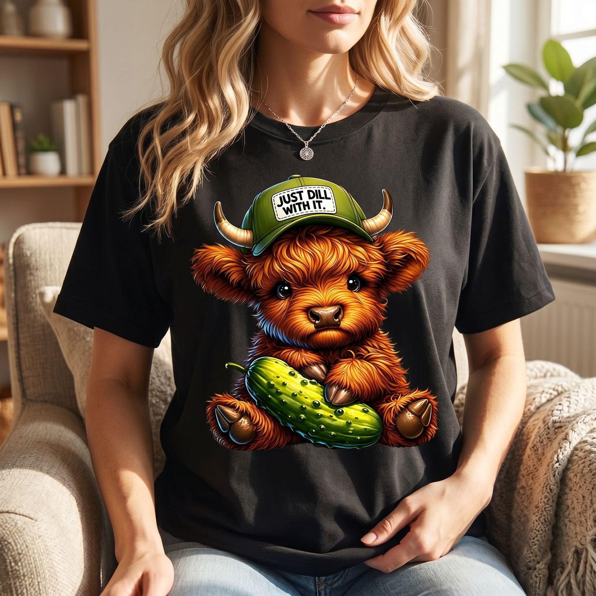 Highland cow T-shirt displayed in a cozy cafe scene with natural warm lighting and inviting atmosphere.