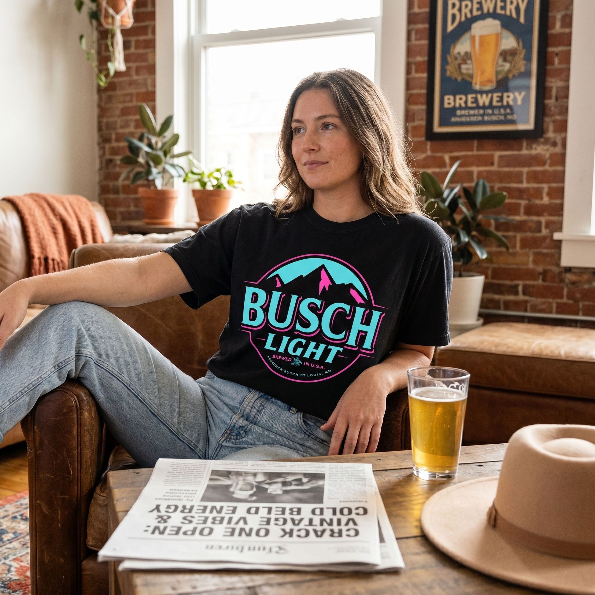 Man enjoying a drink wearing Busch Light Neon Vintage Tee in a comfortable, inviting home setting.